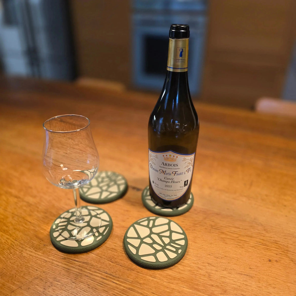 Un verre d'eau posé sur un dessous de verre design Voronoi , protégeant une surface de table moderne.